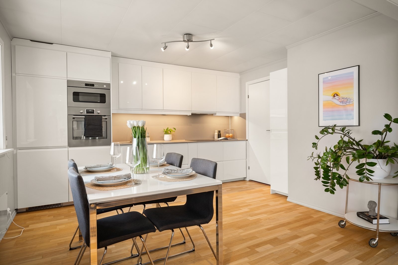 Leiligheten har en åpen løsning mellom stue og et moderne kjøkken fra 2019. Galleribilde