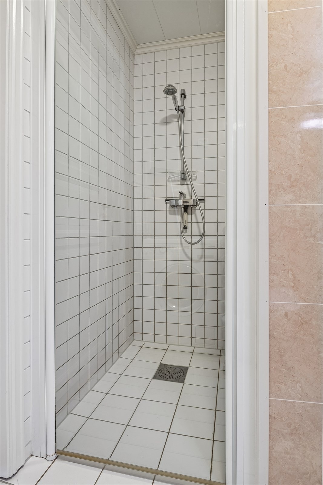 Dusjnisje med flislagte vegger og innfellbare glassdører utnytter plassen godt. Galleribilde