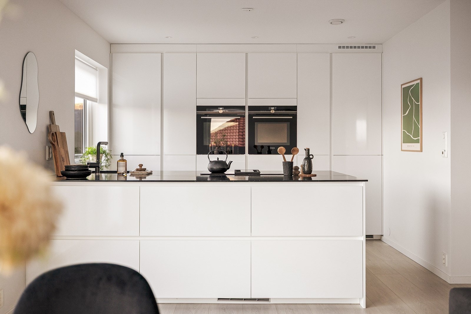 Påkostet kjøkkeninnredning med steinbenkeplate, nedfelt vask og induksjonsplatetopp med integrert ventilator. Galleribilde