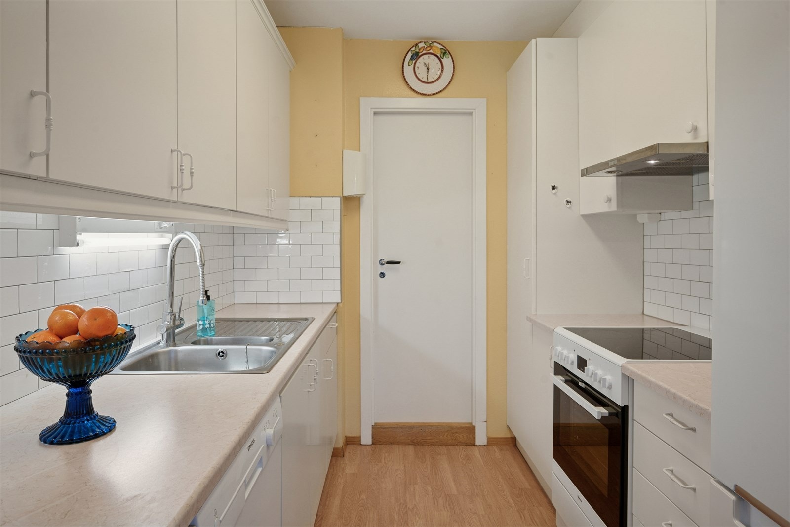 Lyst og tidløst kjøkken med det som måtte være nødvendig av skap-, skuff- og benkeplass. Galleribilde