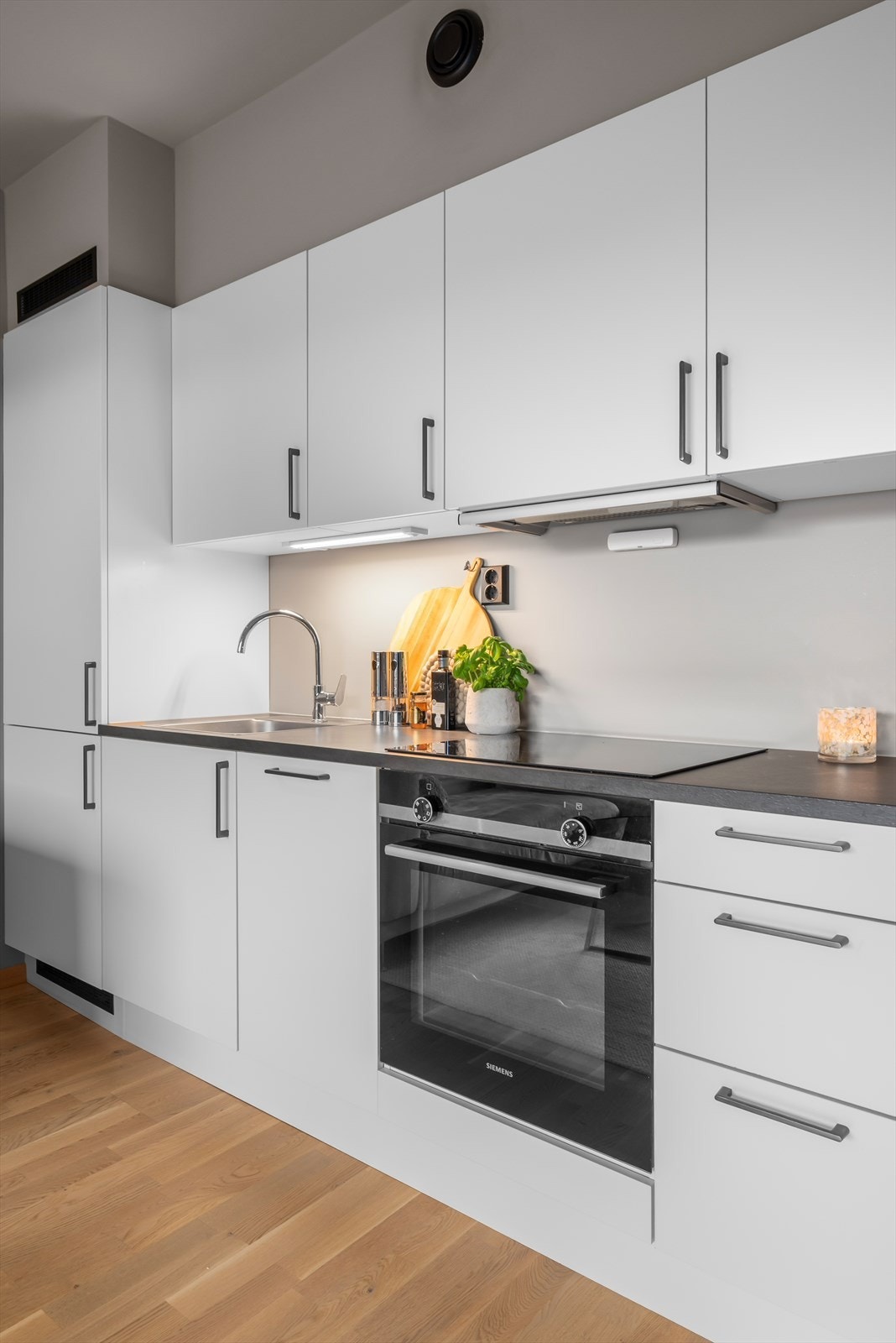 Kjøkkenet er levert av kvalitetsprodusenten HTH og har glatte fronter samt benkeplate i laminat. Innredningen har integrerte hvitevarer som platetopp, stekeovn, oppvaskmaskin og kjøleskap med frysedel under. Galleribilde