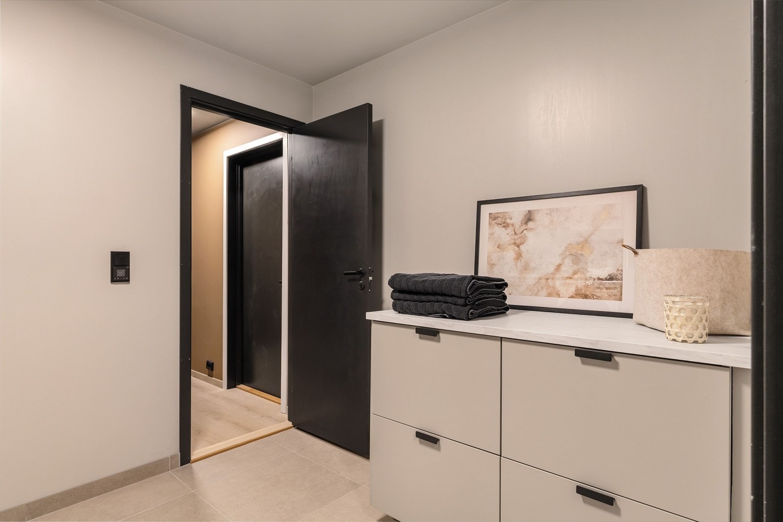 Skap- og benkeløsning gir praktisk oppbevaring og arbeidsflate, og rommet fungerer som en effektiv, separat funksjonssone for klesvask. Galleribilde