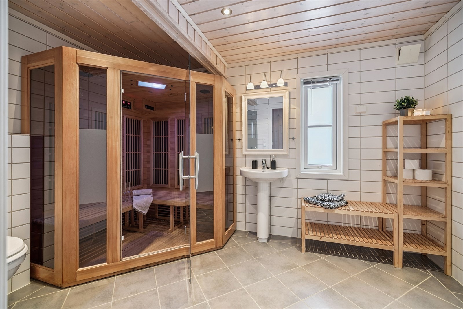 Badet har flislagt gulv med varme, og fliser på gulv og veggene. Galleribilde