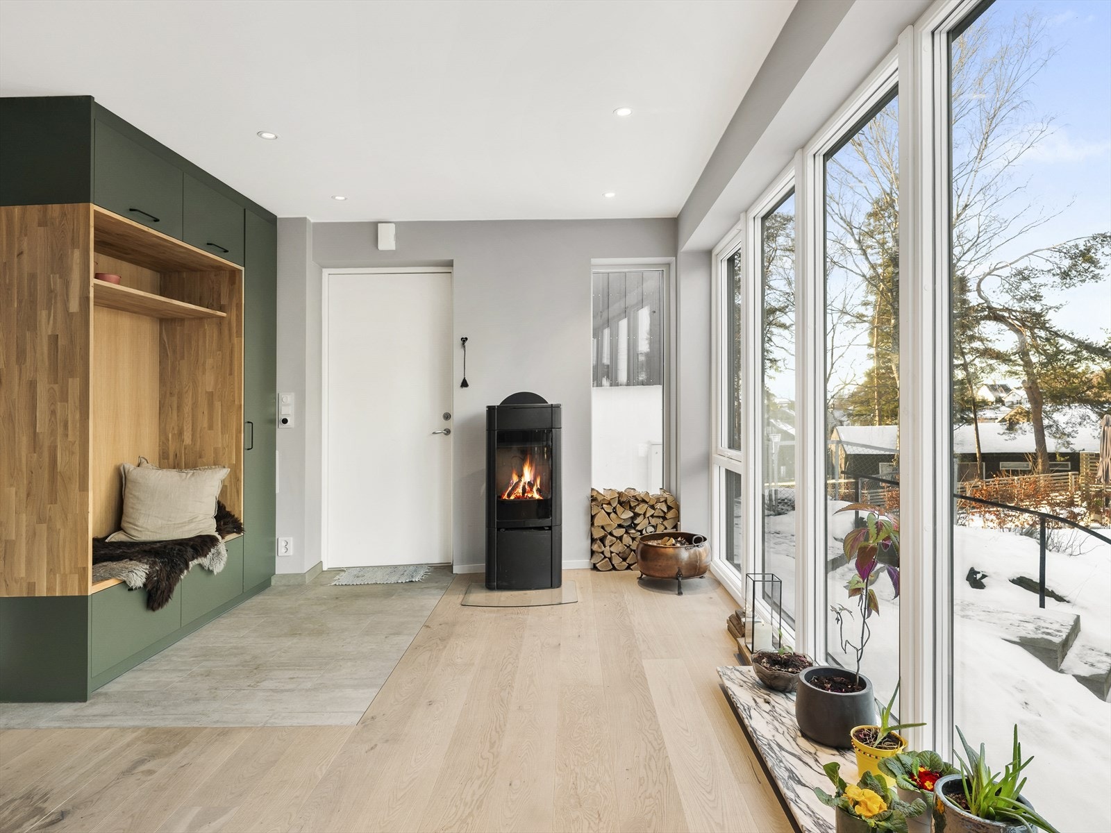 Innbydende inngang med plassbygget garderobeløsning og en stemningsfull peisovn. Galleribilde