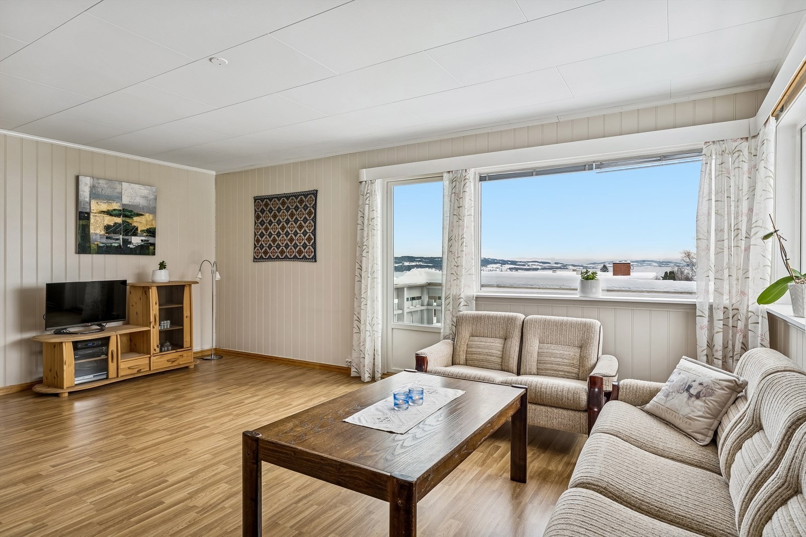 Rommet er lyst med panel på veggene og laminatgulv. Galleribilde