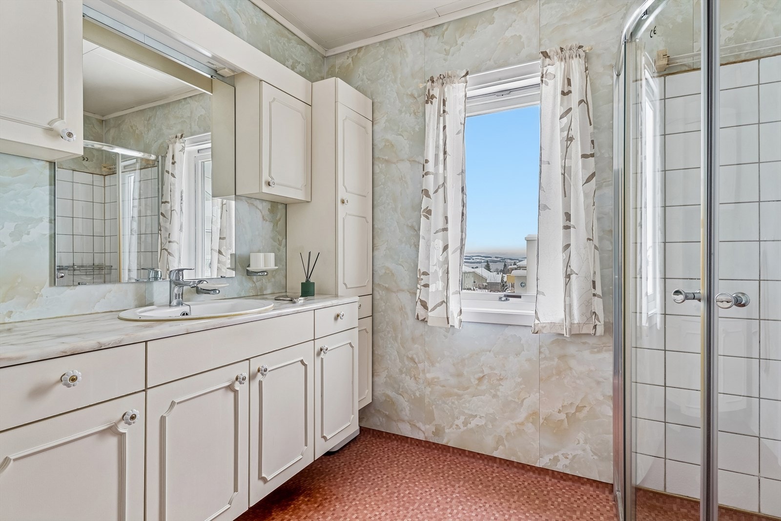 Badet i første etasje har belegg på gulvet, baderomsplater på veggene og servant med underskap. Galleribilde