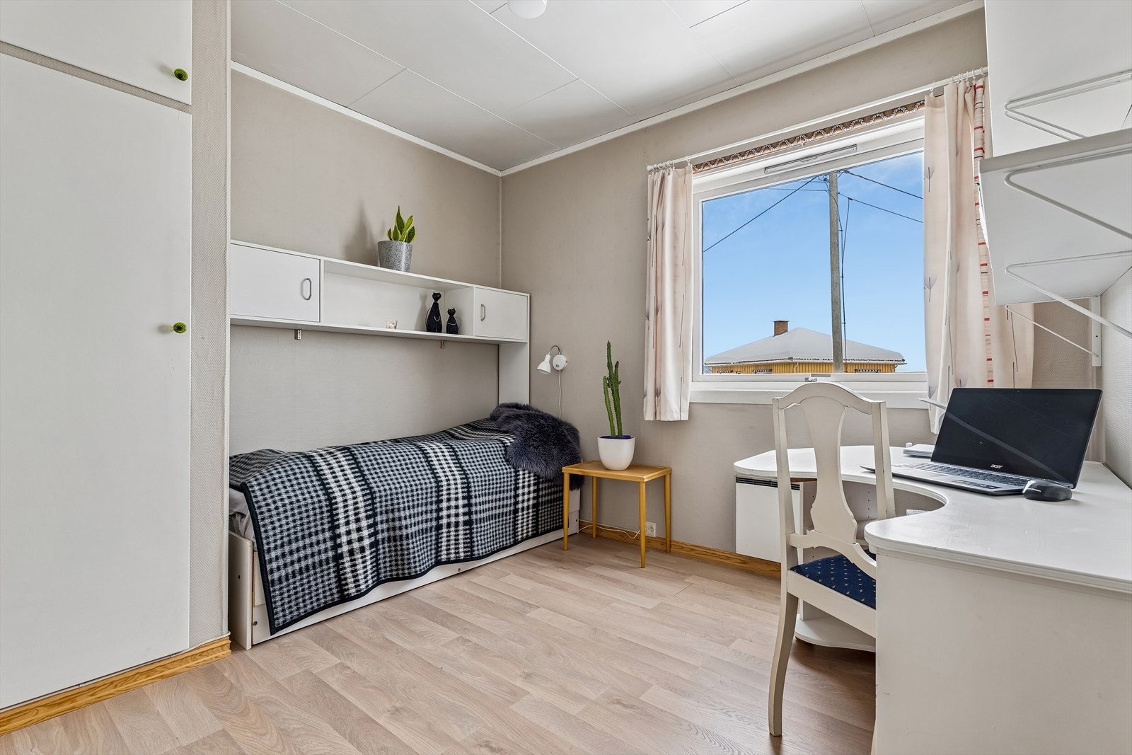 Et av etasjens to soverom, med laminat på gulvet og praktisk skapinnredning. Galleribilde