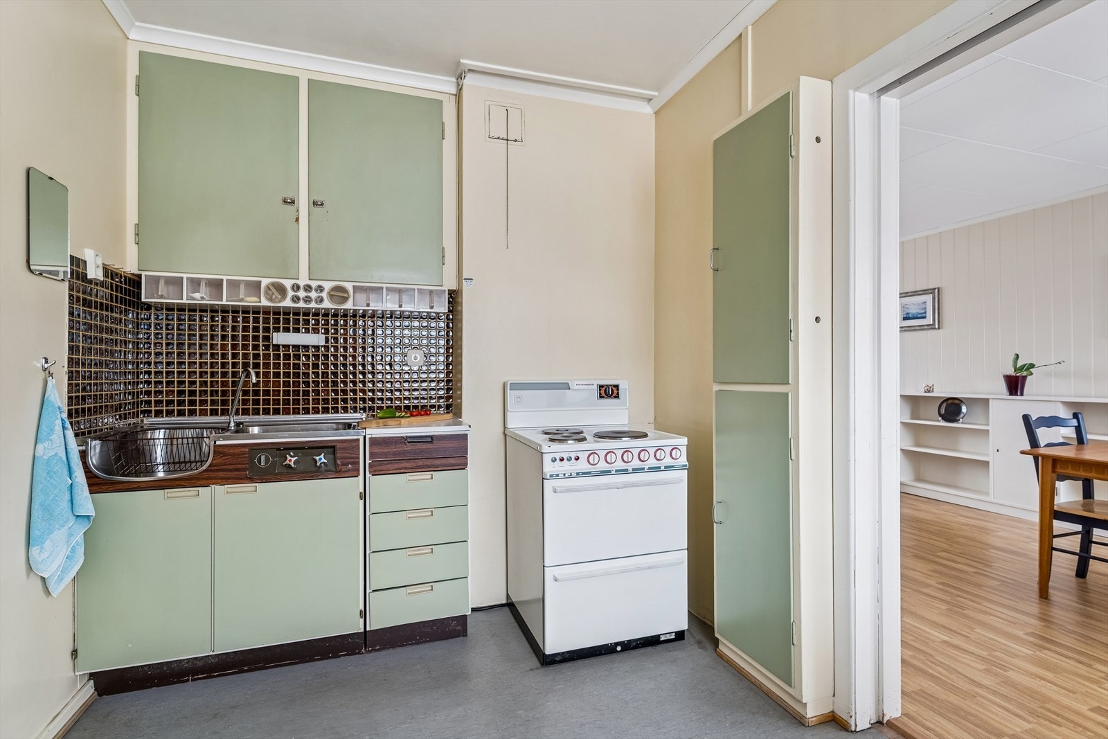 Funksjonelt kjøkkeninnredning med glatte fronter og plass til frittstående komfyr og kjøleskap. Galleribilde