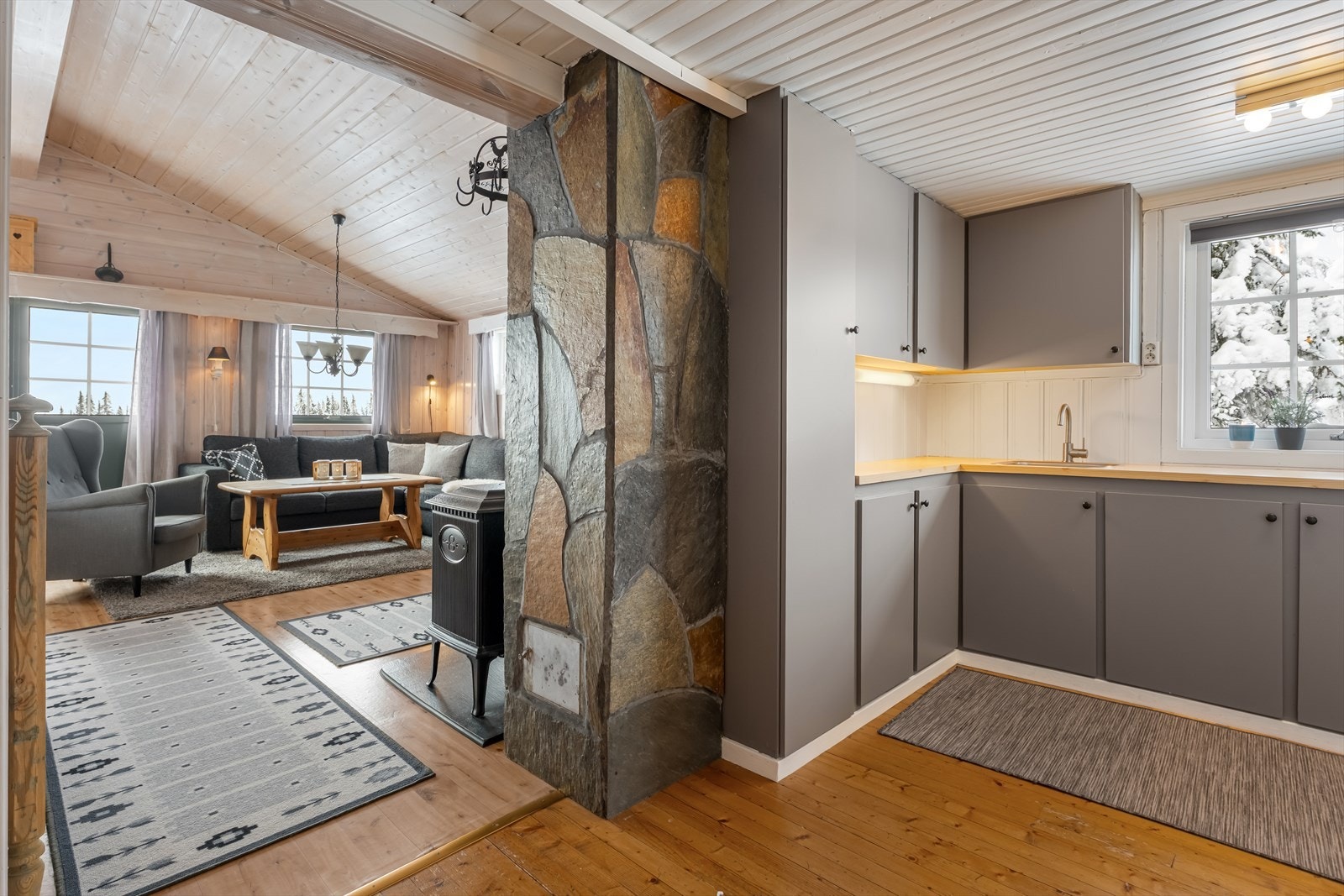 Kjøkken ligger vegg i vegg med stue med stort spisebord. Galleribilde