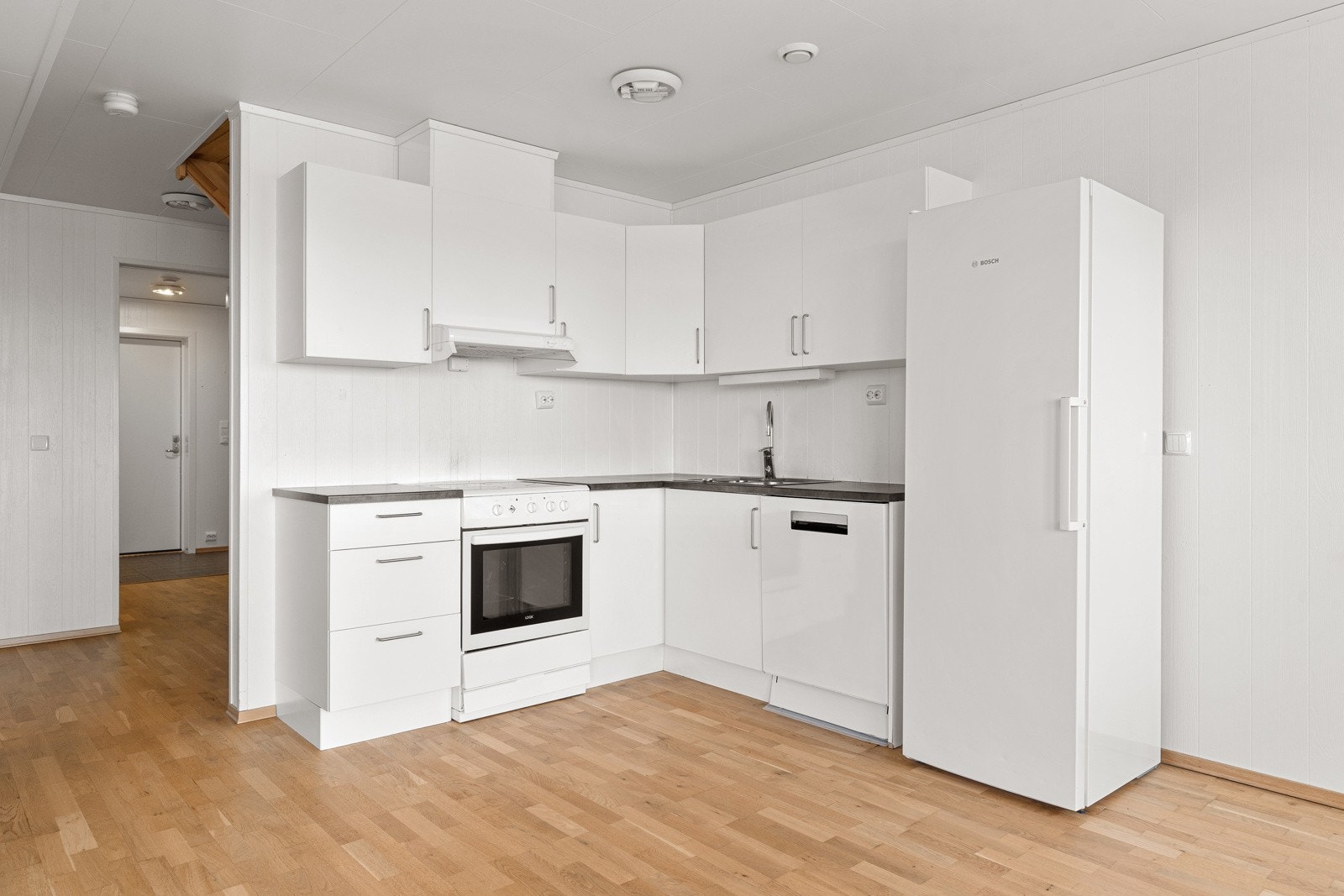 Praktisk og sosialt kjøkken med gode arbeidsflater og slette fronter. Galleribilde