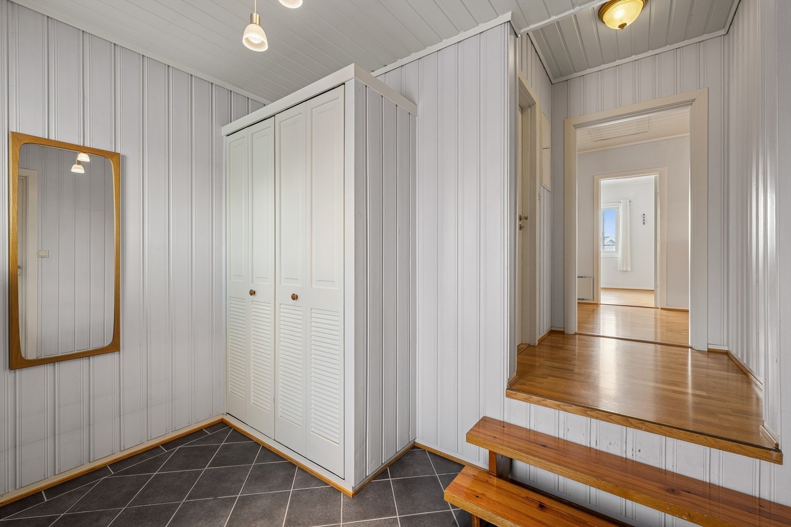 Lys gang med plassbygde skap som utnytter plassen optimalt. Galleribilde