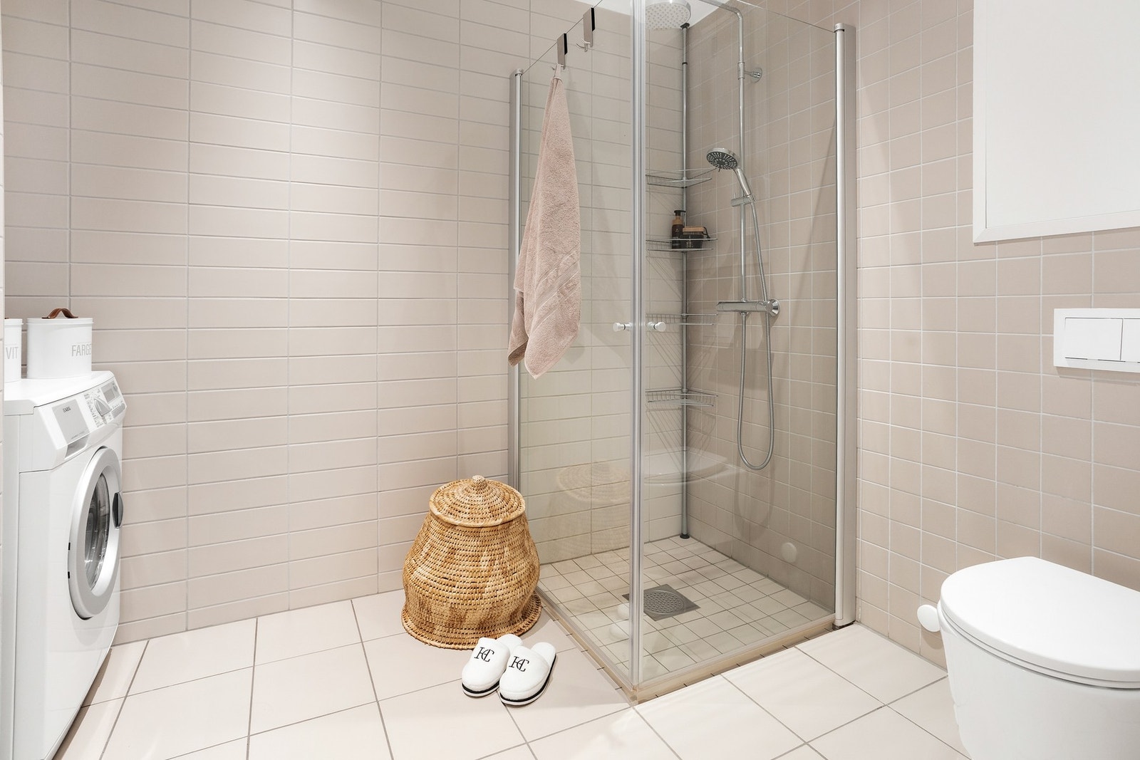 For øvrig er det stilrent dusjhjørne med innfellbare glassdører, krom dusjarmatur med regnfallsdusj og ekstra dusjhode samt vegghengt toalett og opplegg for vaskemaskin Galleribilde