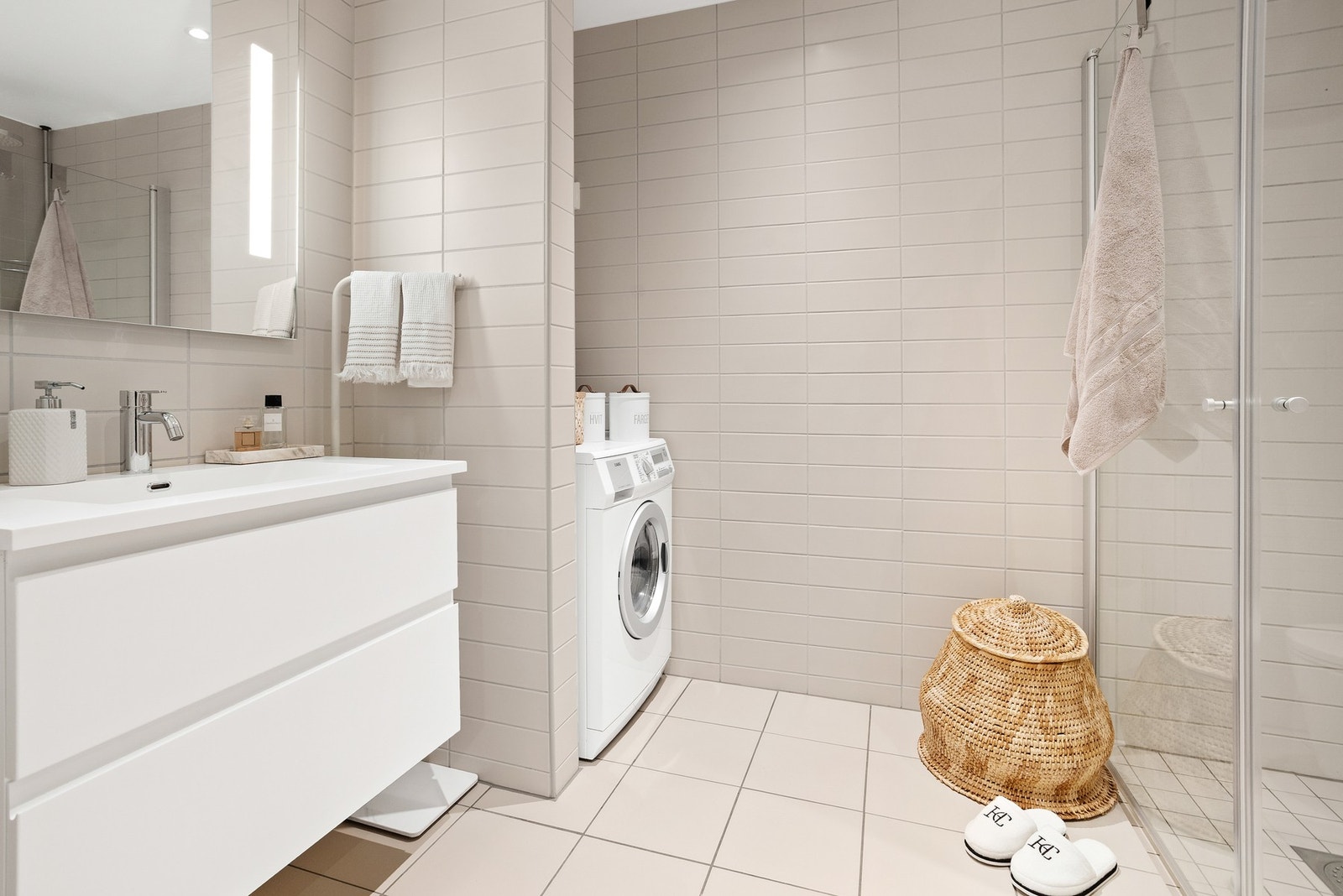 Moderne innredet bad med stilfull baderomsinnredning. Servant med ett-greps blandebatteri, praktiske kolonialskuffer og vegghengt speil Galleribilde