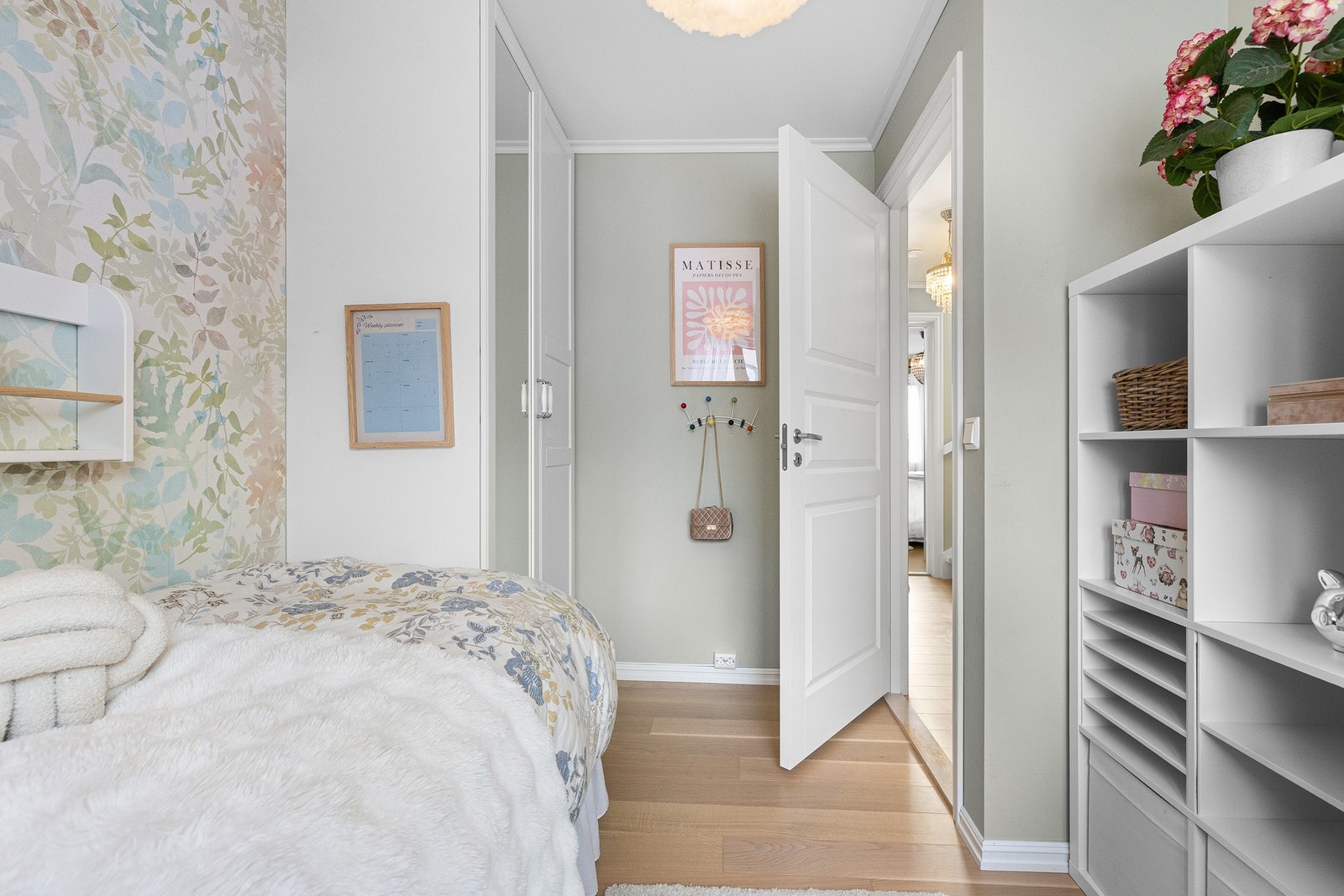 Soverom 3 er malt i en behagelig, lys grønntone med parkett på gulv, og én vegg er tapetsert i en fargepalett som harmonerer fint med øvrige flater. Galleribilde