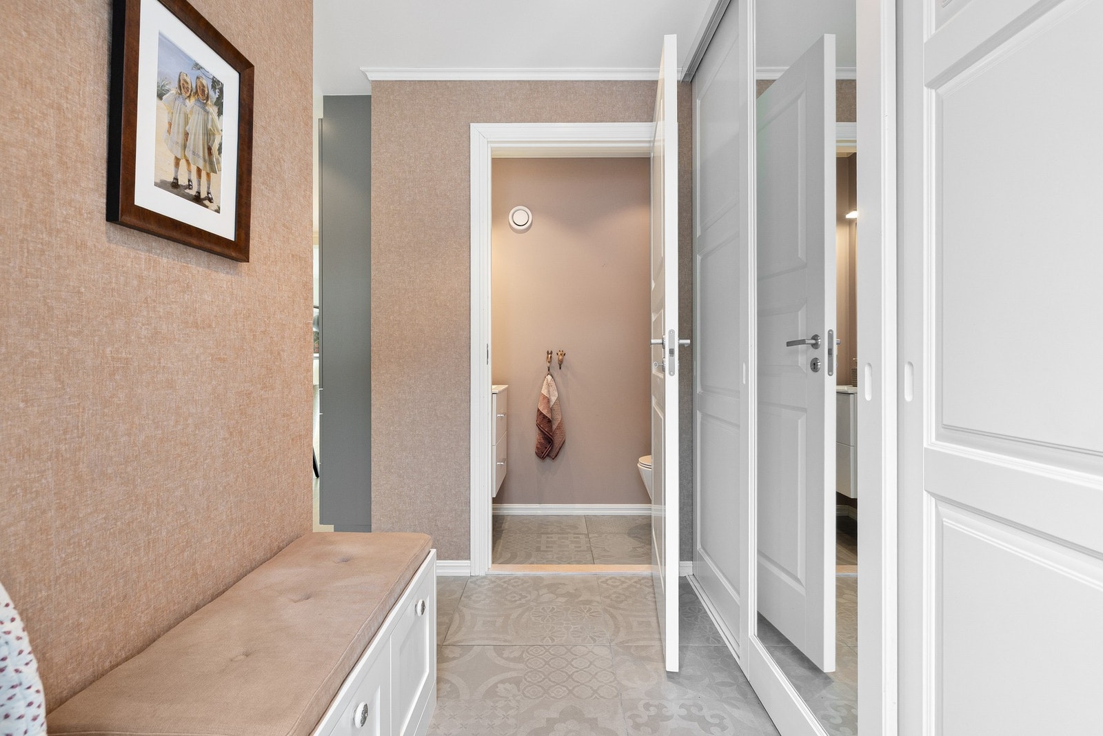 Selger har gjort flere tilvalg i boligen som løfter både funksjon og uttrykk, herunder oppgraderte fliser i entréen med gulvvarme, romslig garderobeskap fra Rival og en snekkerbygd sittebenk levert av Elen Møbelstudio. Galleribilde