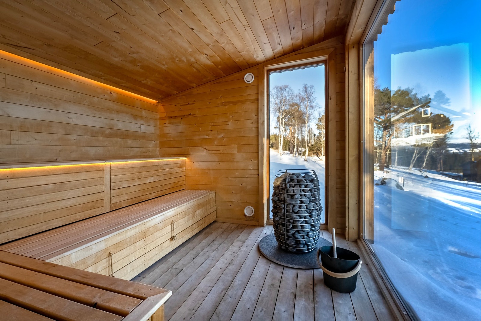 Innredet benker av heltre og steinsatt badstuovn. Galleribilde