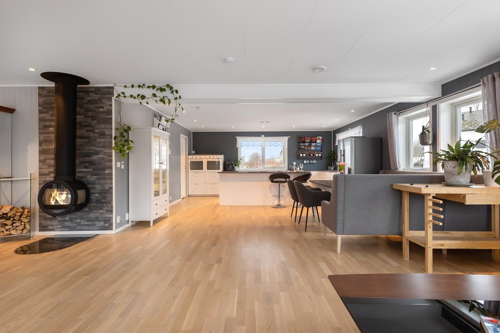 Stort kjøkken med kjøkkenøy og integrerte hvitevarer. Galleribilde