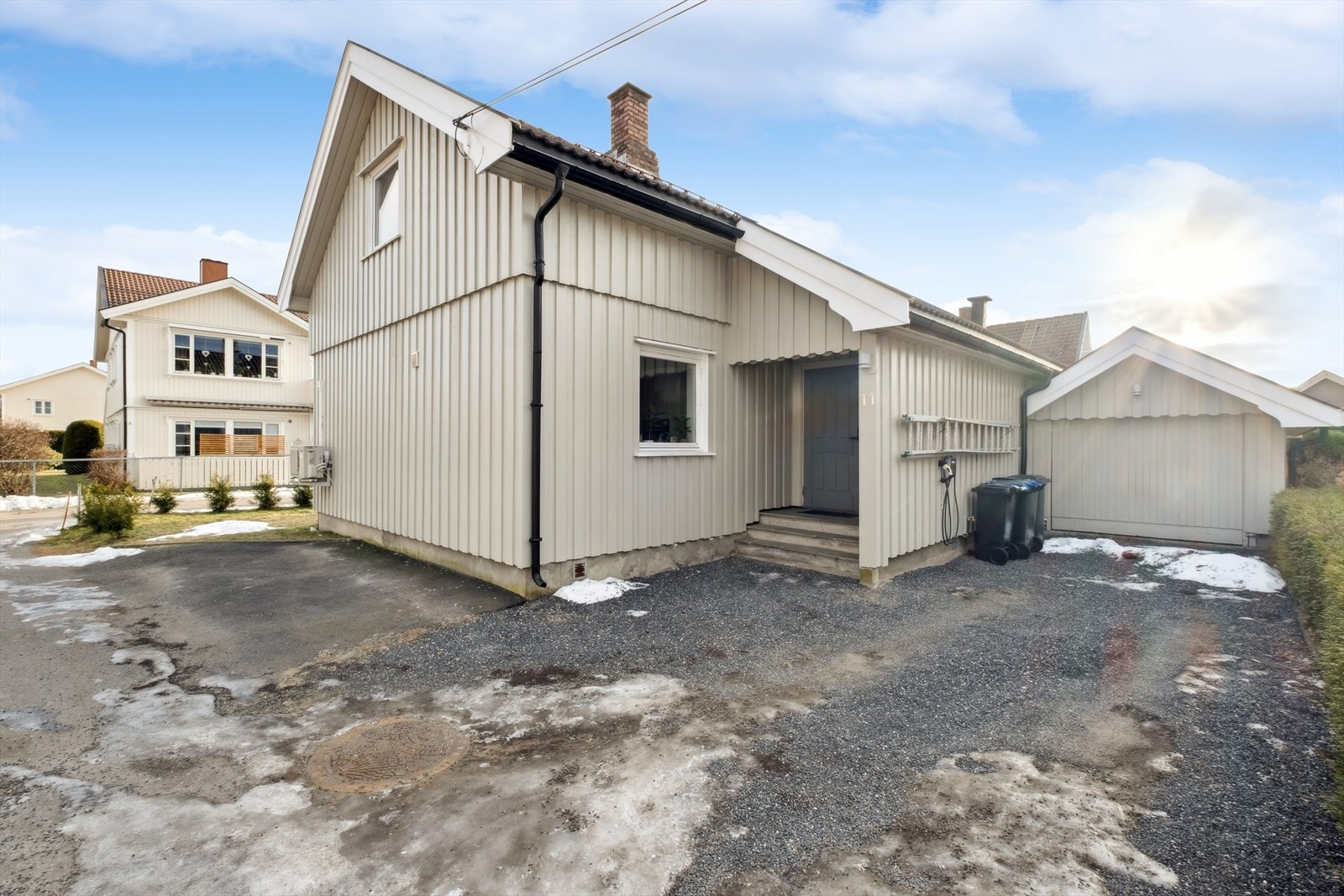 Det er gruset og asfaltert parkeringsplass på tomten, i tillegg til frittstående garasje. Det er montert elbil-lader i husveggen Galleribilde