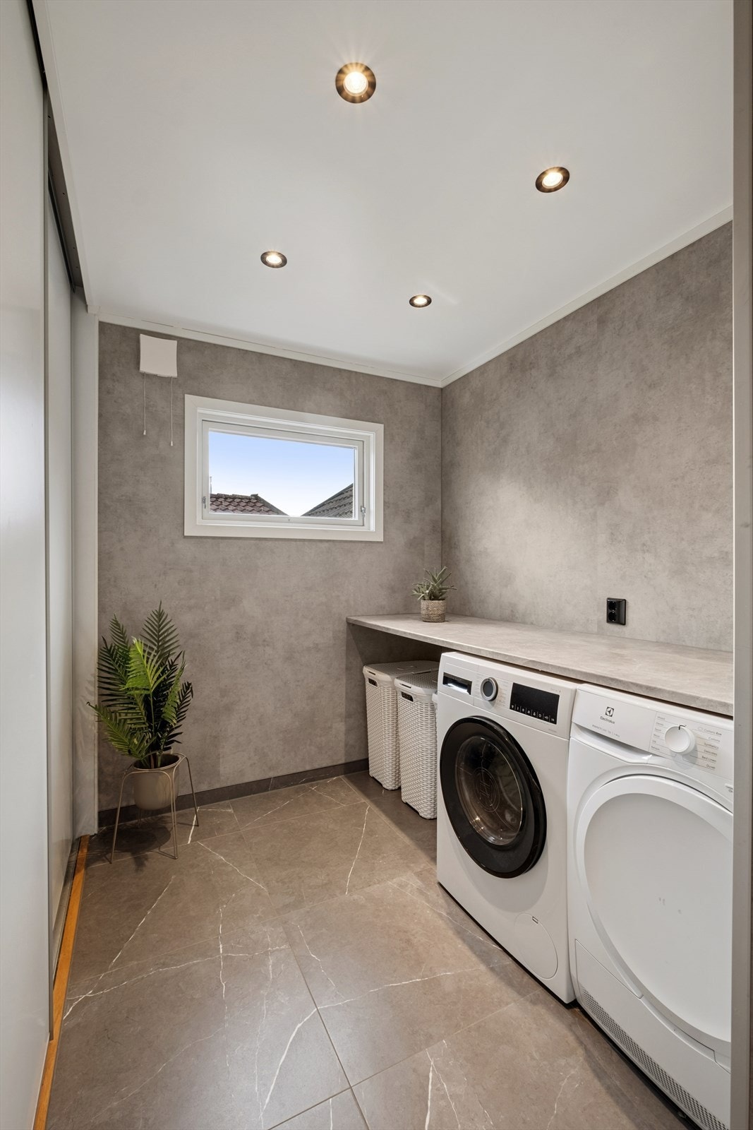 Badet er innredet med dusjnisje, servant med underskap, toalett og opplegg for vaskemaskin og tørketrommel Galleribilde