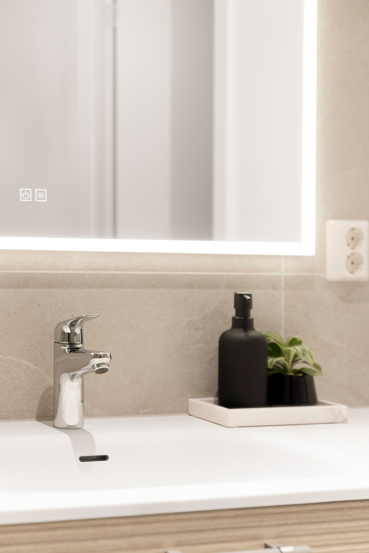 Vegghengt servantinnredning med skuffer og ovenpåliggende servant, samt speil med integrert belysning på vegg. Galleribilde