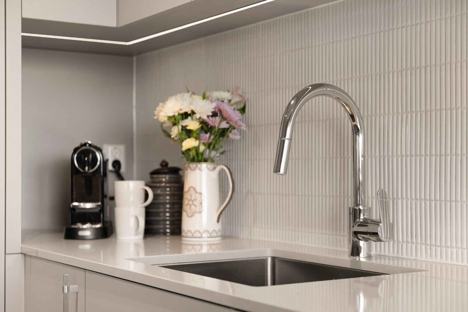 Veggflaten over kjøkkenbenken er flislagt, noe som bidrar til enkelt vedlikehold og forhindrer skader på vegg som følge av vannsprut eller stekeos Galleribilde