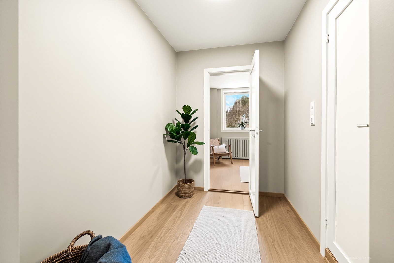 En lys og innbydende gang binder rommene i leiligheten sammen. Galleribilde