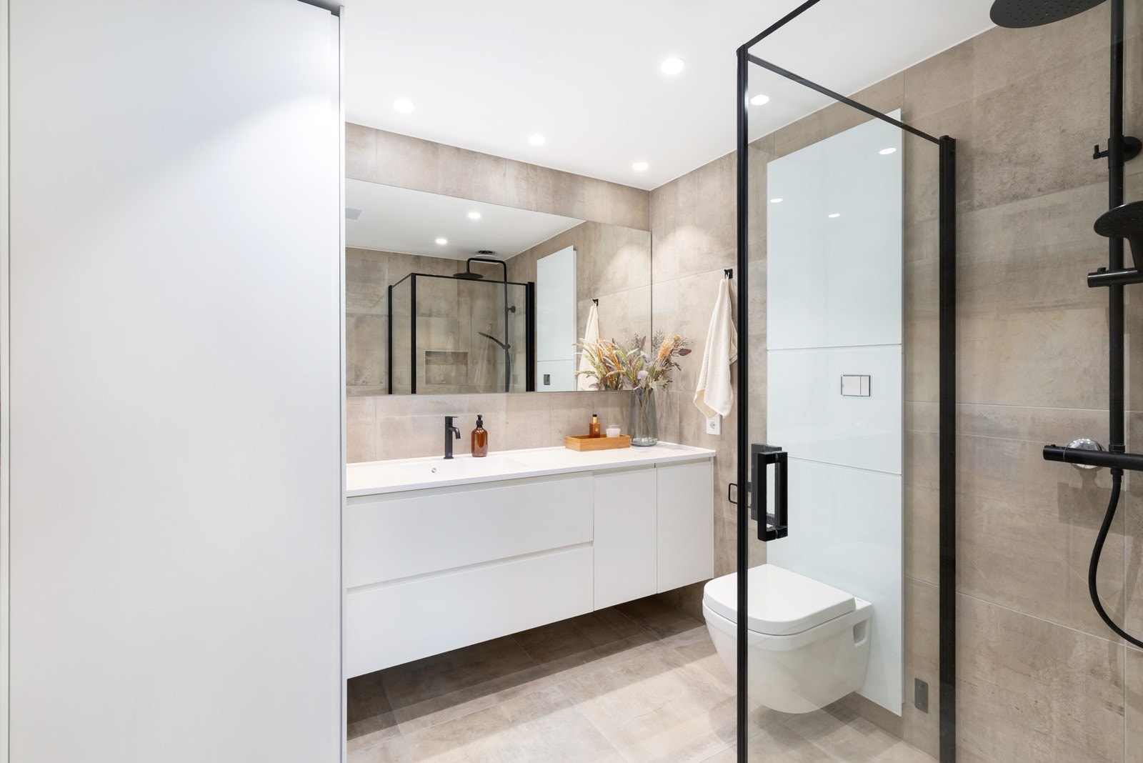 Begge boligens bad er helfliset og pene. Bak skapveggen til høyre i bildet finner du opplegg for vaskemaskin og tørketrommel. Galleribilde