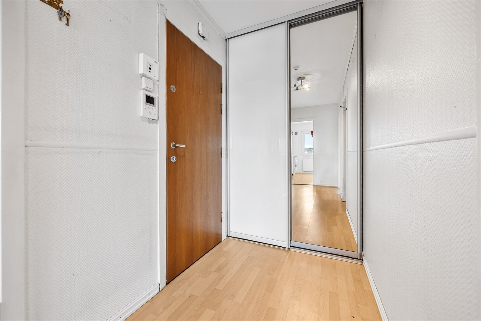 Velkommen inn i en entré med plass til oppbevaring i skyvedørsgarderobe. Galleribilde