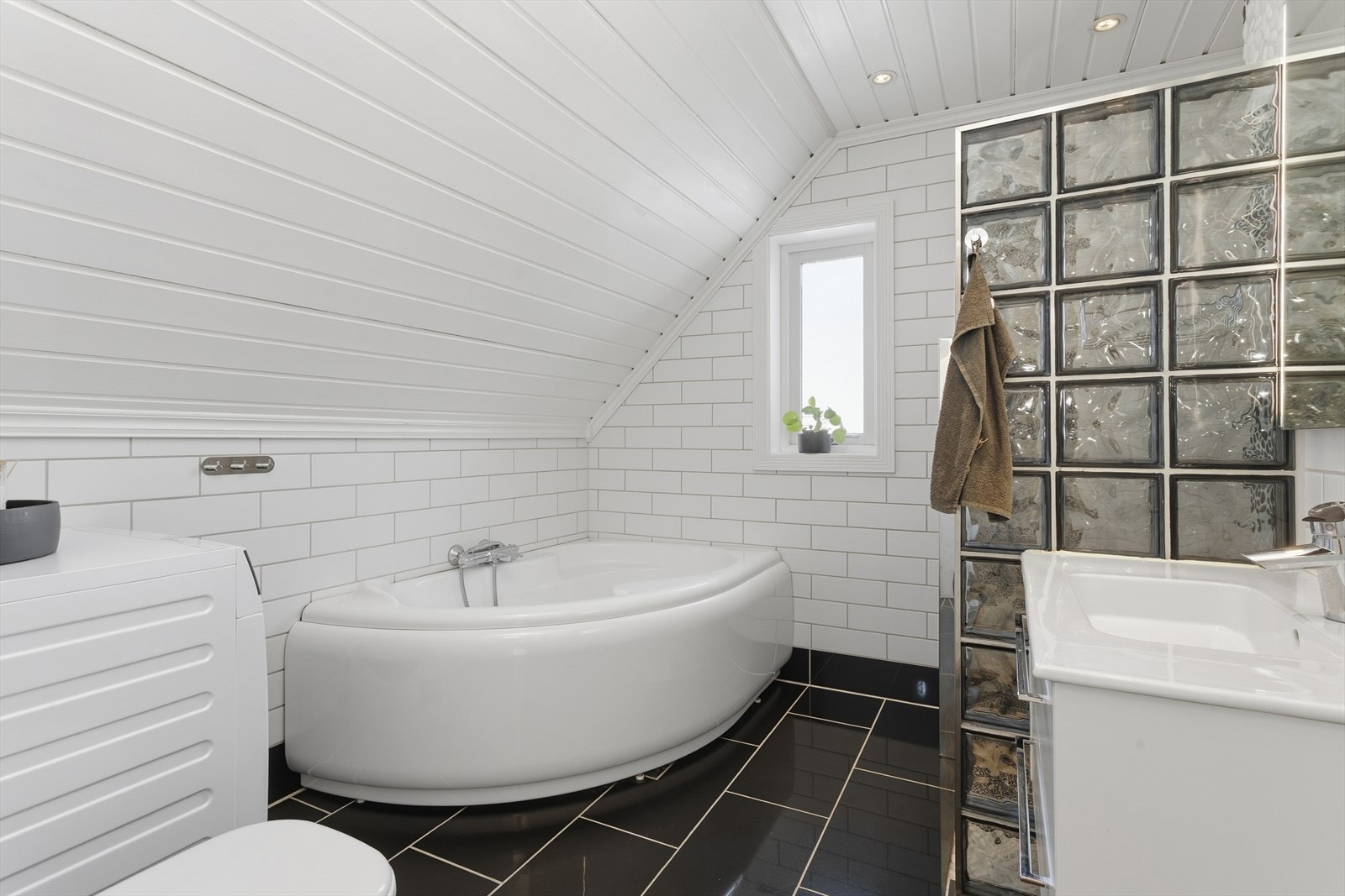 Romslig bad med gode løsninger og opplegg for vaskemaskin. Galleribilde