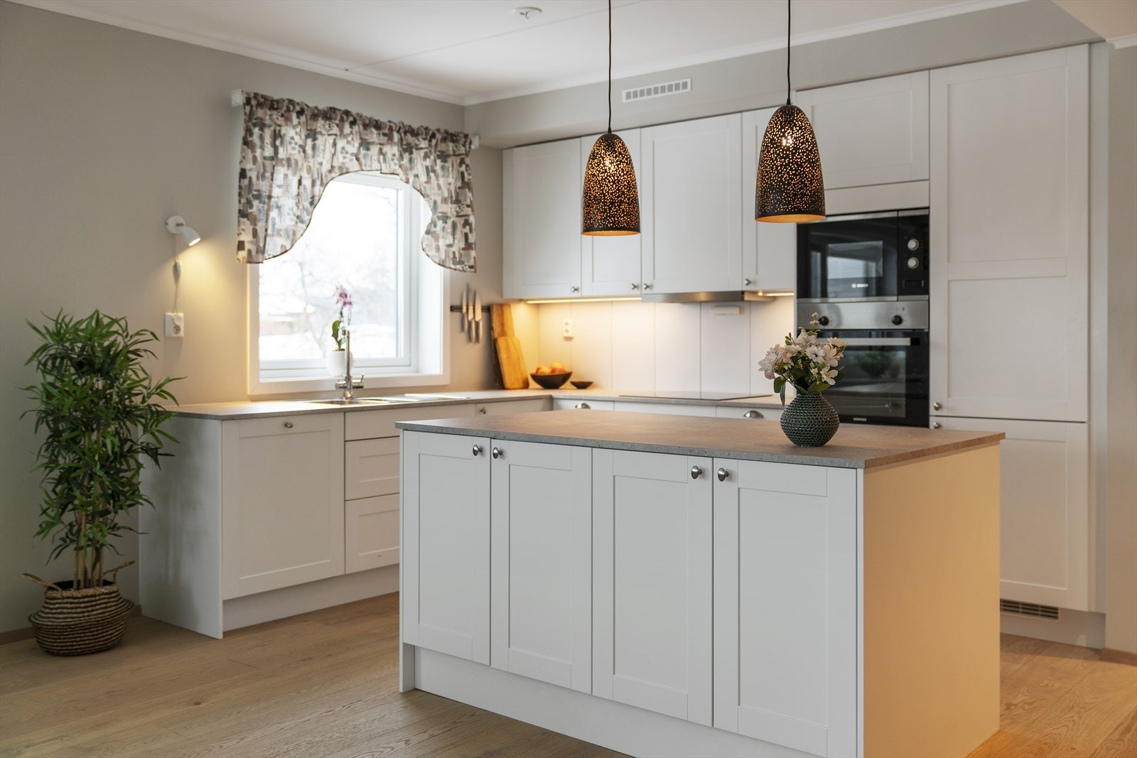 Delikat kjøkkeninnredning fra Sigdal med hvite lett profilerte fronter og laminert benkeplate Galleribilde