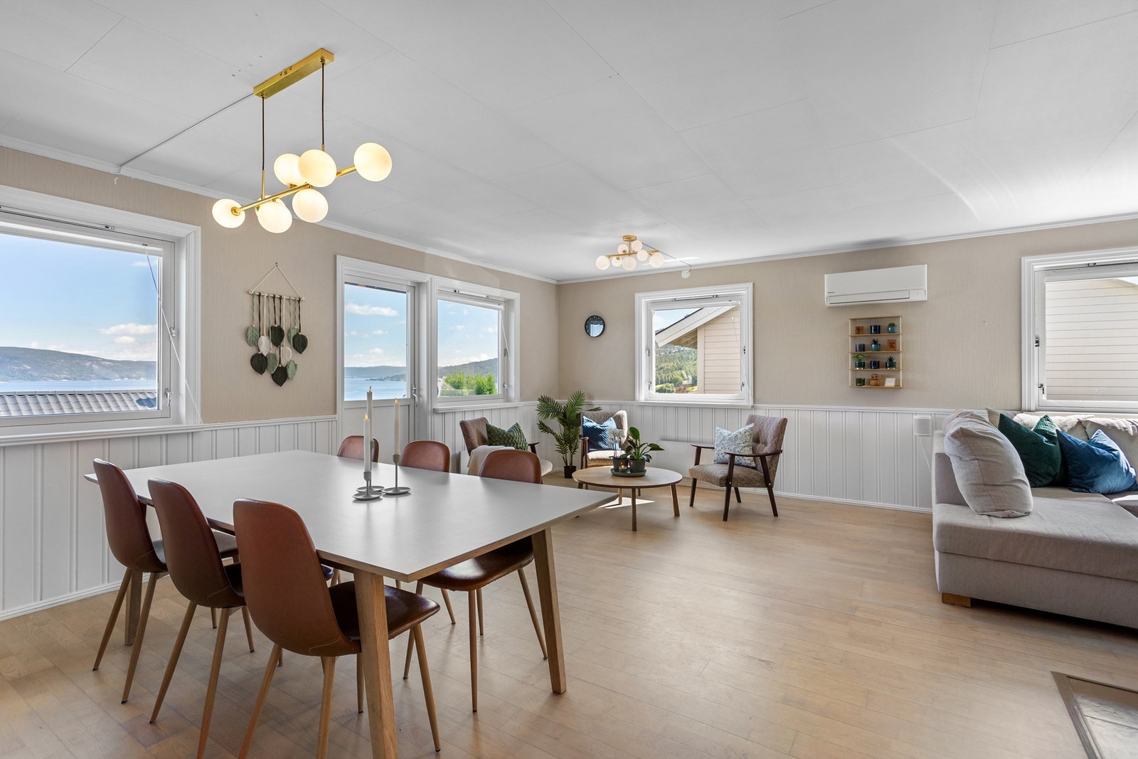 Lys og luftig vinkelstue med sofaområde, spiseplass samt sittegruppe Galleribilde