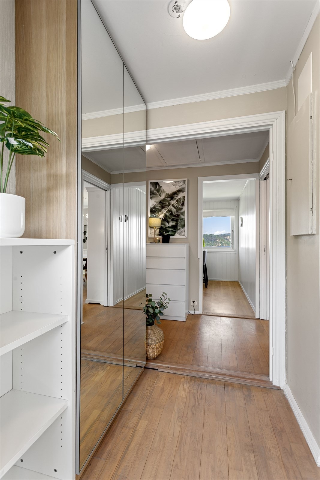 Entré med garderobeskap som har speilfronter Galleribilde