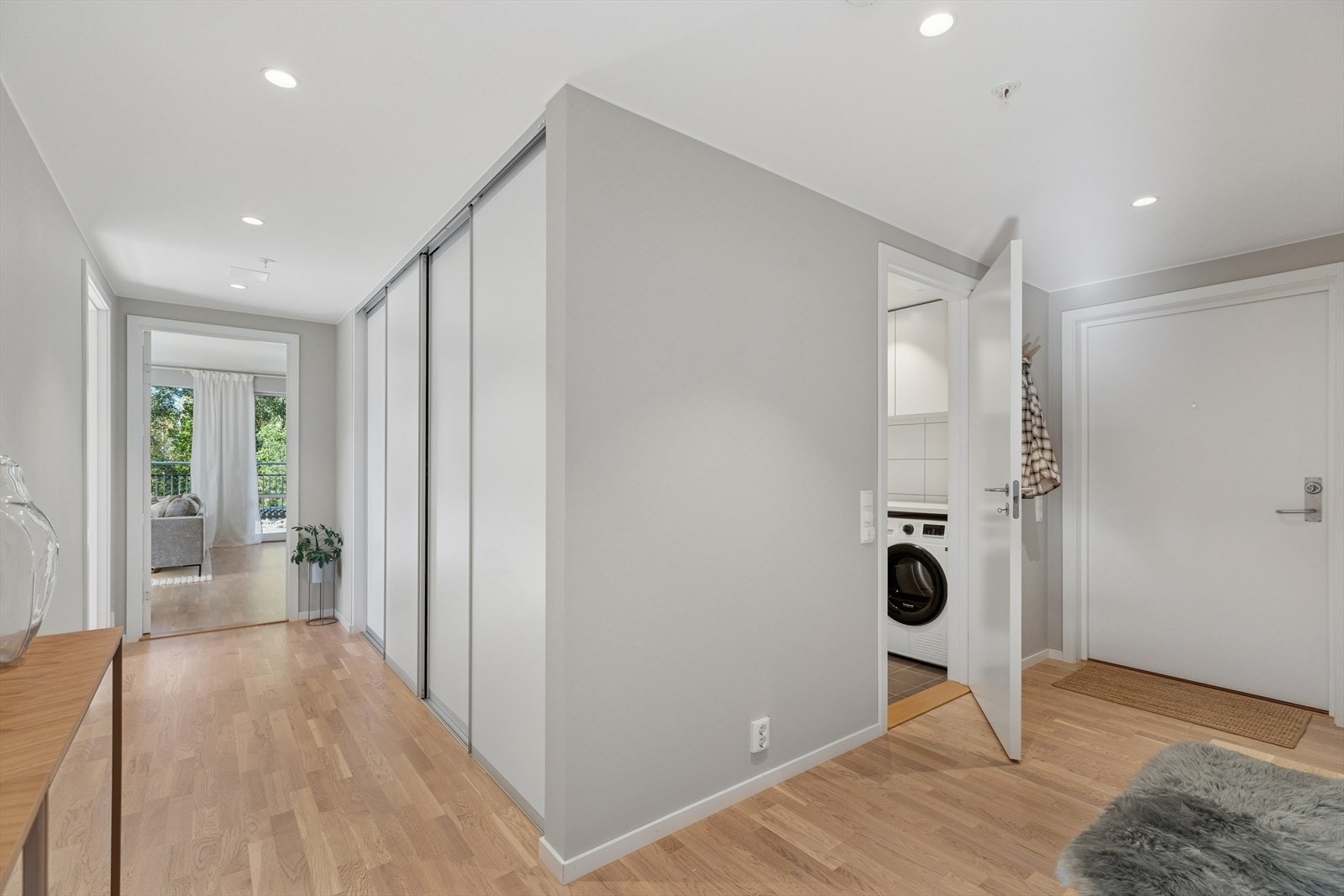 Romslig og innbydende entré med praktisk skyvedørsgarderobe. Galleribilde