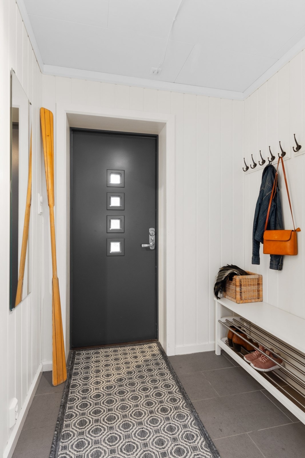 En hyggelig entré med flislagt gulv ønsker deg velkommen inn i leiligheten. Galleribilde