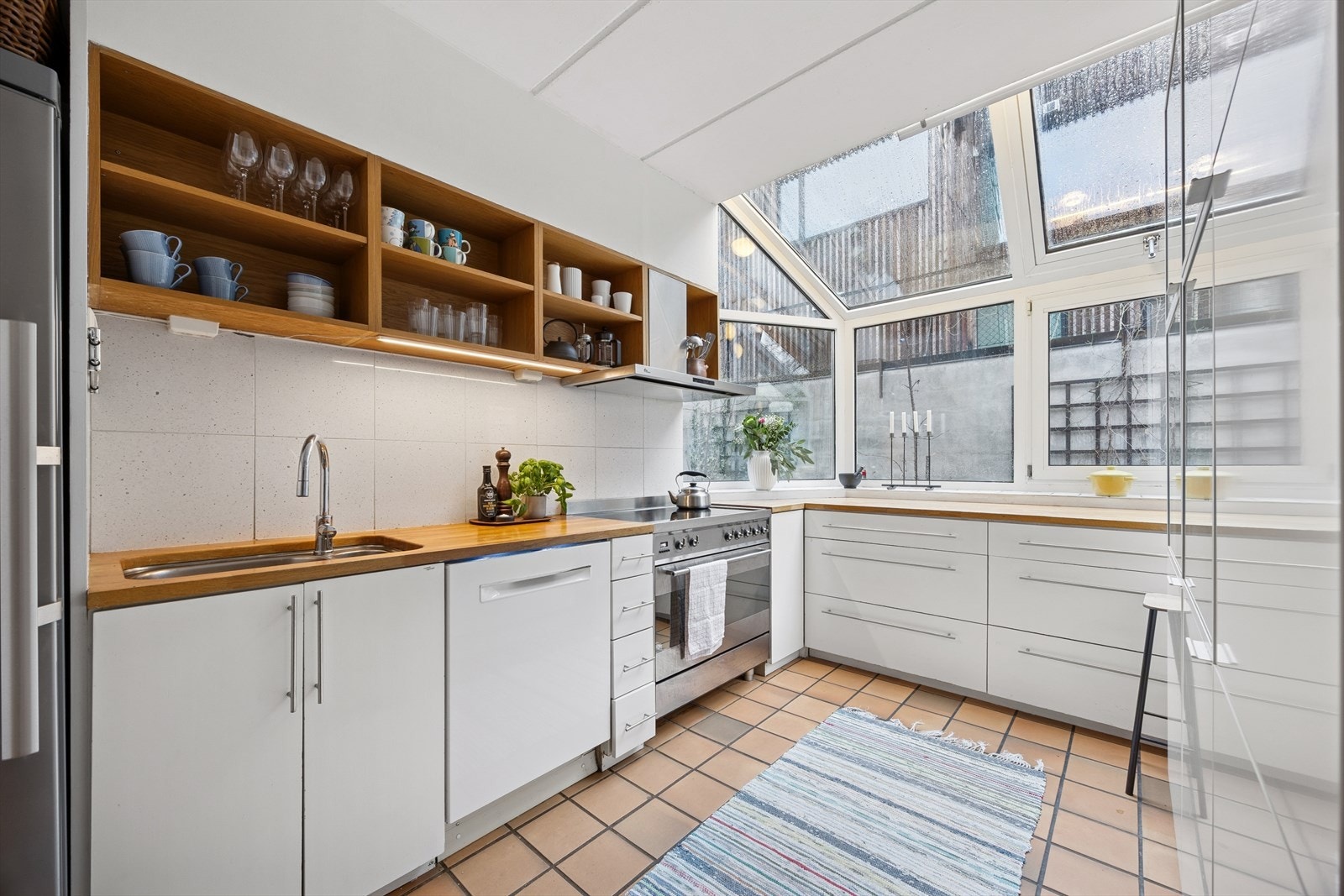 Kjøkkeninnredning med glatte fronter og en heltre benkeplate med nedfelt vask. Galleribilde