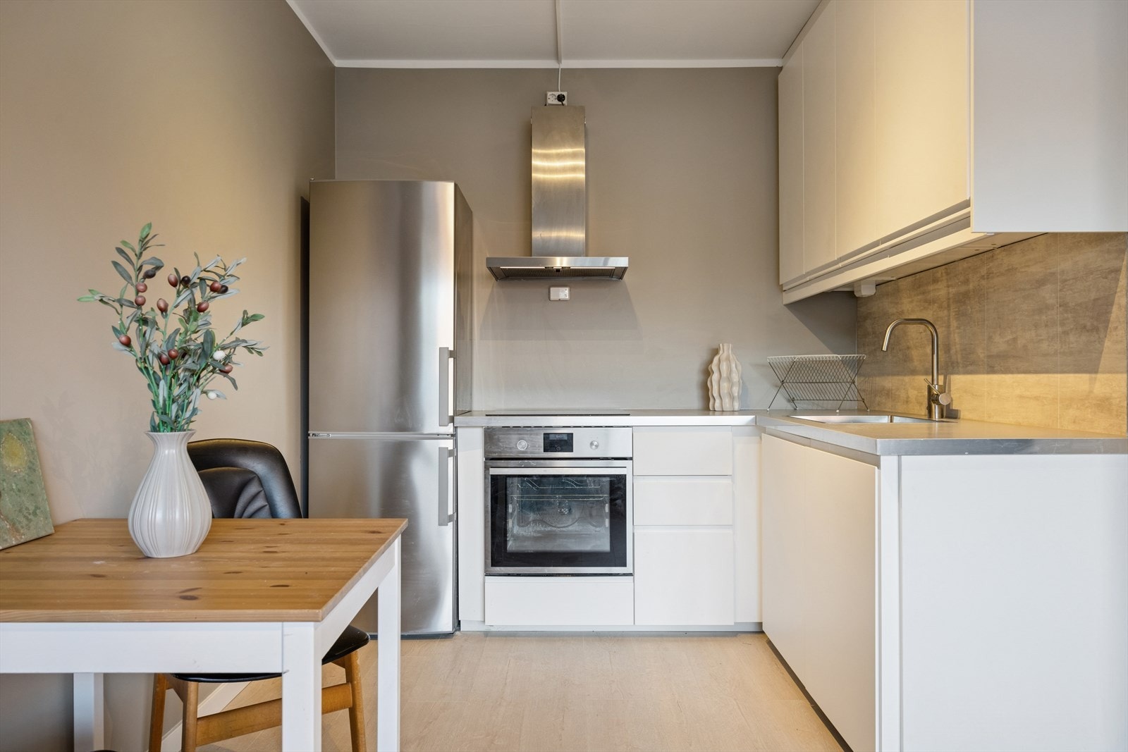 Integrerte hvitevarer inkluderer oppvaskmaskin, stekeovn og mikrobølgeovn, mens benkeplaten er laminert for enkel rengjøring. Galleribilde