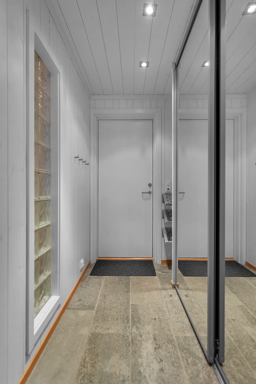 Skifer i gang/entrè med stor skyvedørsgarderobe til oppbevaring av ytterklær og sko. Galleribilde