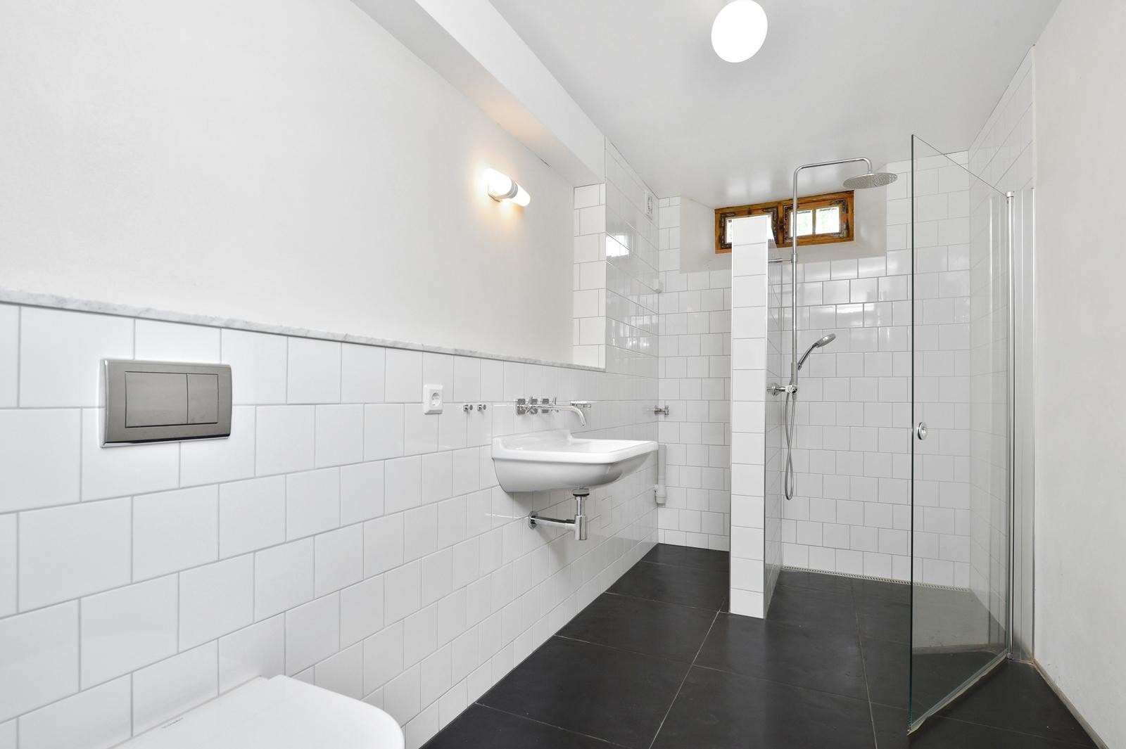 Flislagt baderom med opplegg for vaskemaskin. Galleribilde