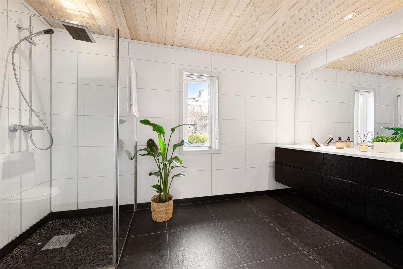 Romslig bad i hovedetasjen som i 2011 ble gjennoppbygd etter lekkasje. Flislagt gulv med gulvvarme, baderomsplater på vegger og panelt tak. Dusjhjørne med glassvegger og vegghengt dusjarmatur med hånddusj og regndusj. Galleribilde