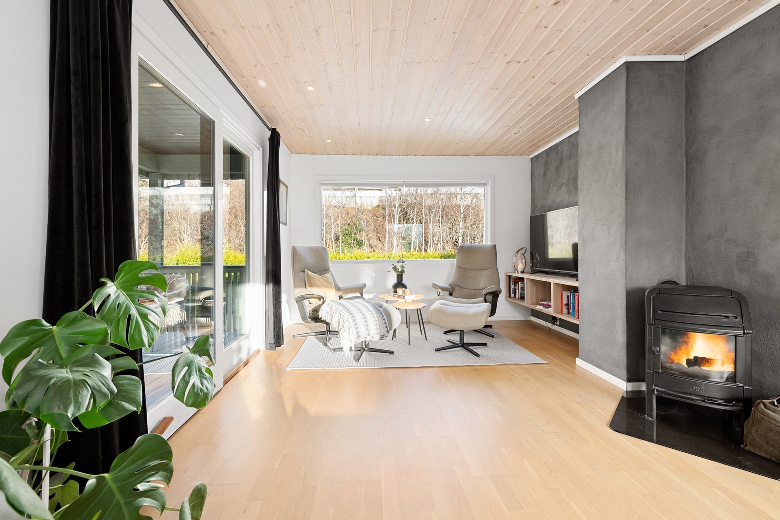 Fra sofagruppen på stuen mot tv-kroken. Skyvedører mot vest til terrasse med trapp til terreng og hage Galleribilde