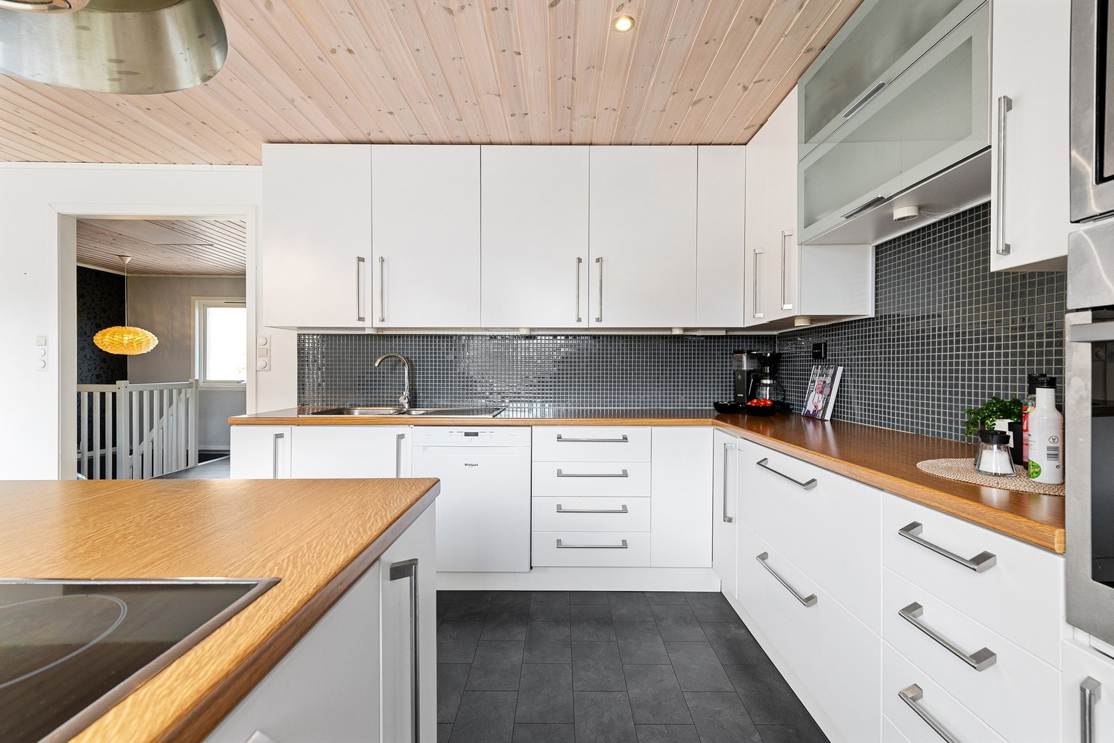 Romslig kjøkkeninnredning med takhøye skap og god skapplass. Galleribilde