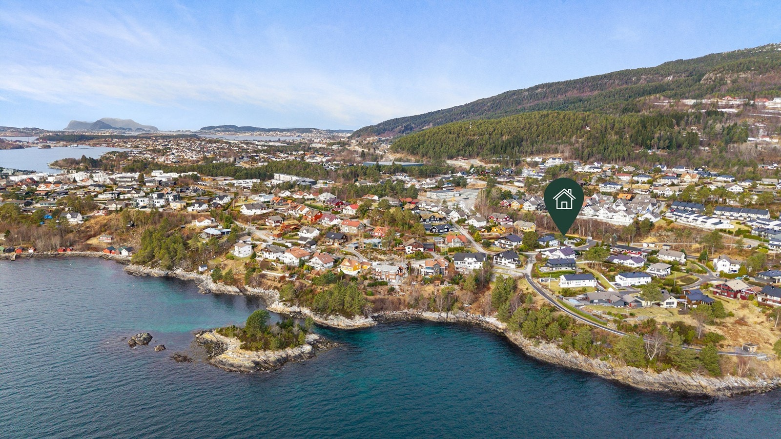 Dronebilde av boligområdet tatt fra sjøsiden med eiendommens plassering markert Galleribilde