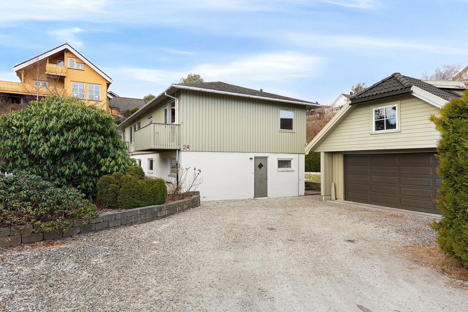 Stor gruslagt gårdsplass og parkeringsrearealer foran dobbel garasje Galleribilde