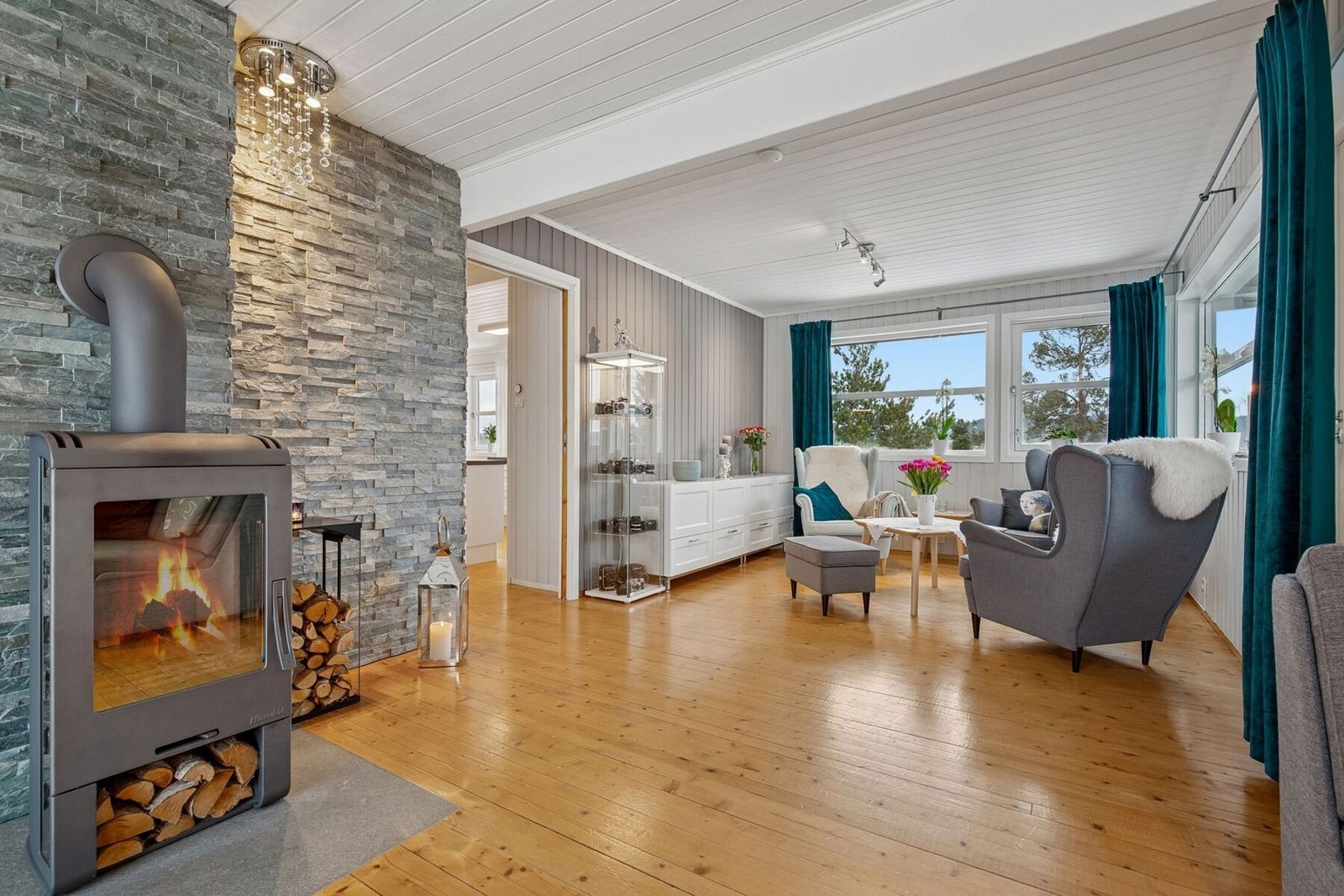 Behagelig vedfyring i peis plassert sentralt i stua for et behagelig inneklima. Galleribilde