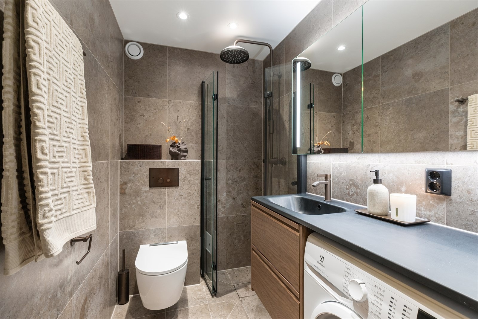 Flislagt baderom med gulvvarme som ble totalrenovert i 2025. Badet er utstyrt med servantskap med glatte folierte fronter, speilskap med lysarmatur. Galleribilde