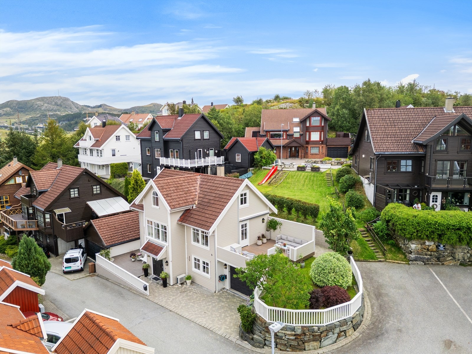Tomten er pent opparbeidet med natursteinsmur, beplantet hage, to terrasser og steinsatt gårdsrom. Galleribilde