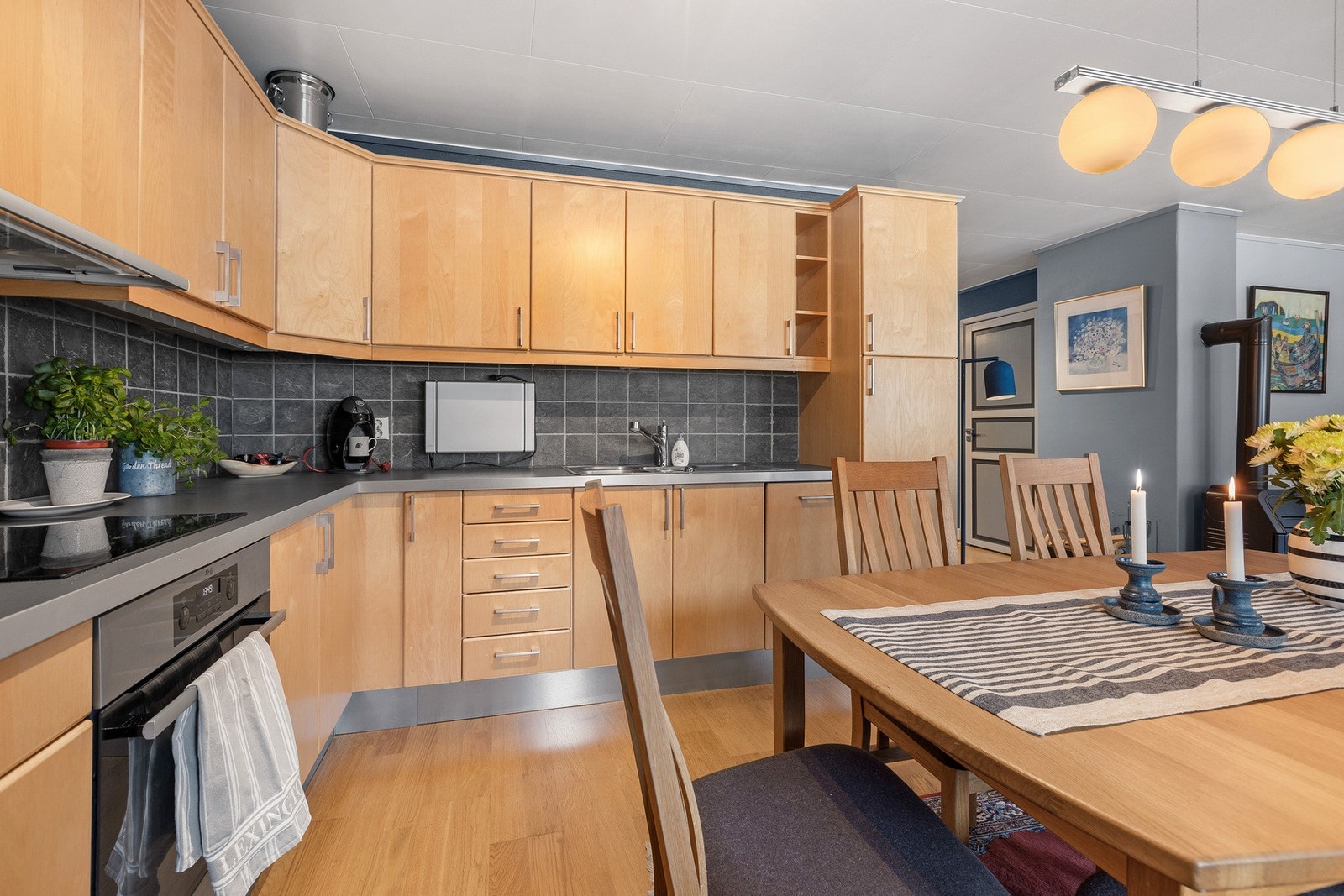 Kjøkkenet har innredning med glatte, lyse finerfronter og laminat benkeplate. Galleribilde