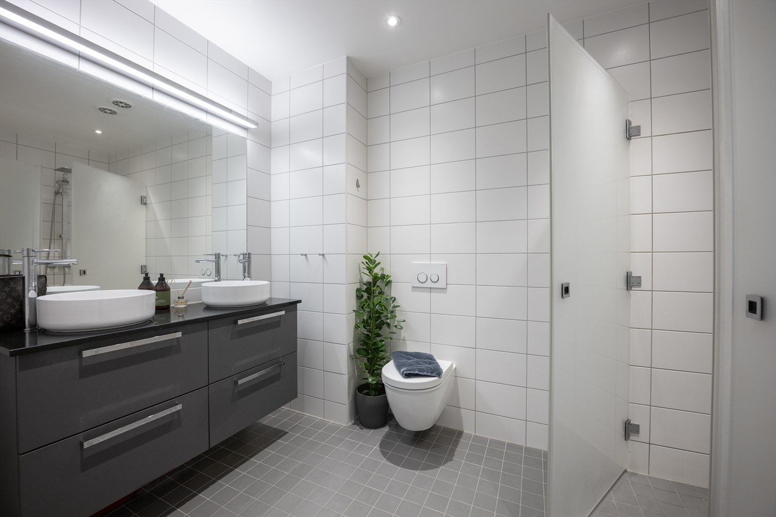 Pent og funksjonelt fliselagt bad med god plass og praktisk planløsning - elektriske varmekabler i gulv Galleribilde