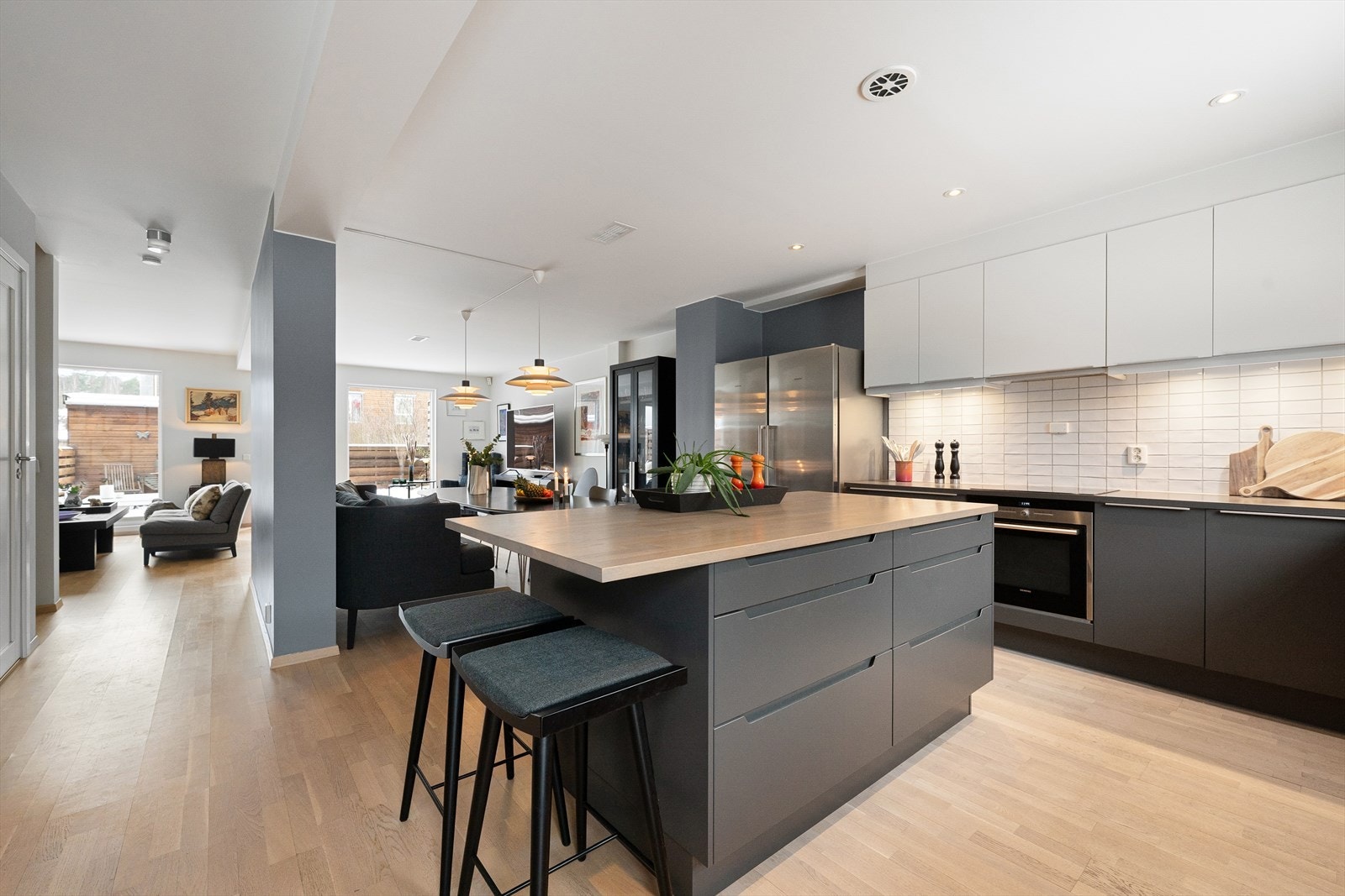 Moderne og innbydende kjøkken med glatte fronter og frittstående kjøkkenøy som gir rikelig med arbeidsflate og en sosial sone for både hverdag og selskap Galleribilde