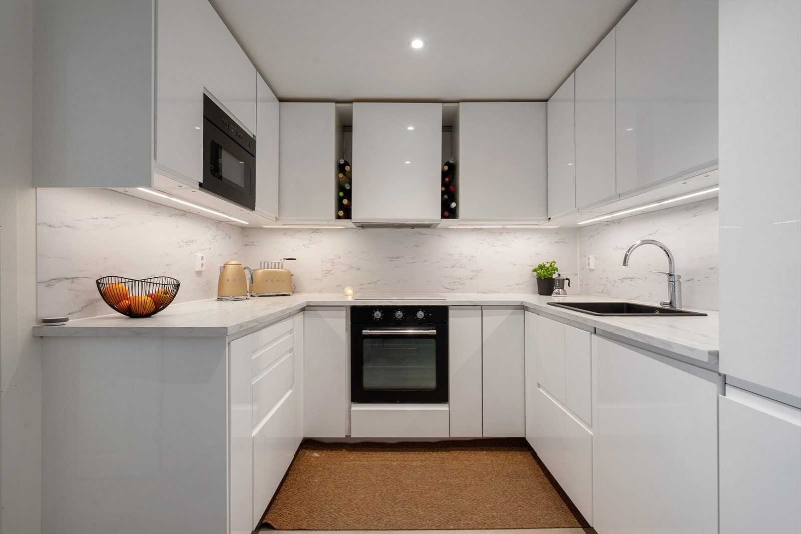 Kjøkkenet er fra 2022 og har en moderne innredning med glatte, hvite fronter og laminatbenkeplate med nedfelt komposittkum. Galleribilde